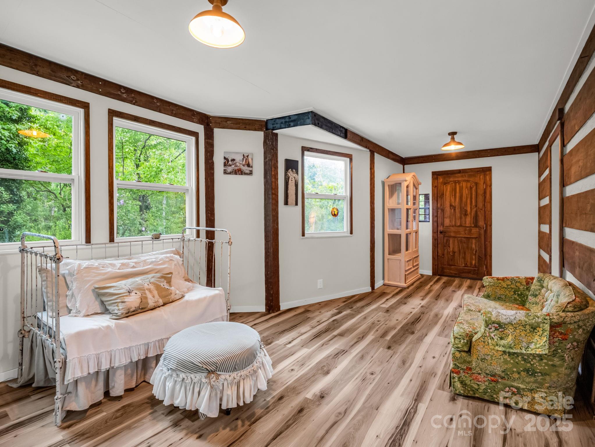 1145 Bearwallow Mountain Road Hendersonville, NC 28792 - Photo 23 of 48 a bedroom with a bed and wooden floor