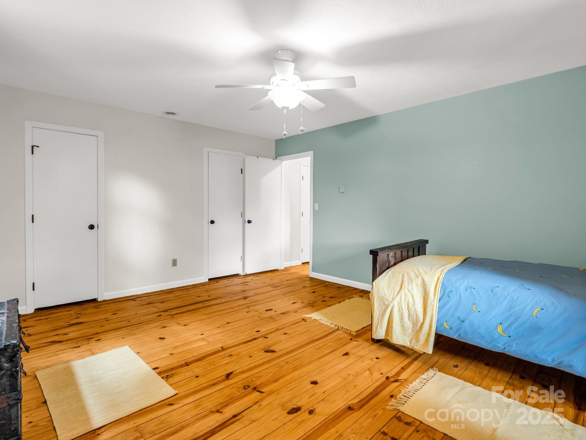 1145 Bearwallow Mountain Road Hendersonville, NC 28792 - Photo 30 of 48 a bedroom with a bed and a chandelier
