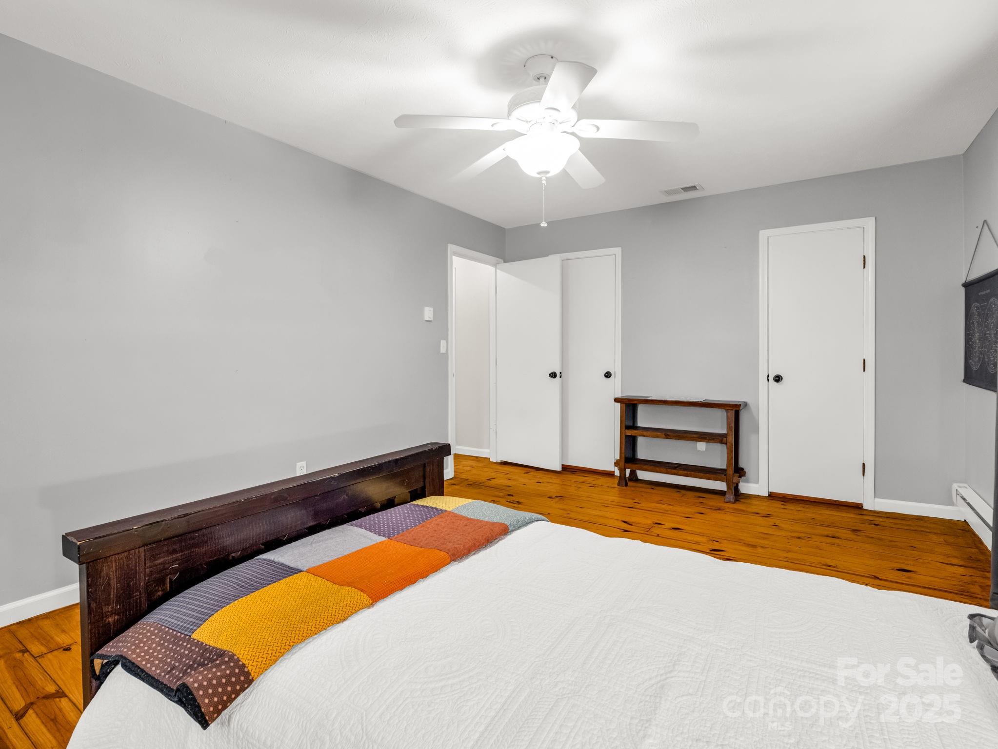 1145 Bearwallow Mountain Road Hendersonville, NC 28792 - Photo 35 of 48 a bedroom with a bed and a chandelier