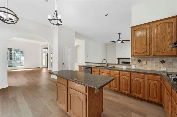a kitchen with granite countertop a sink cabinets and wooden floor