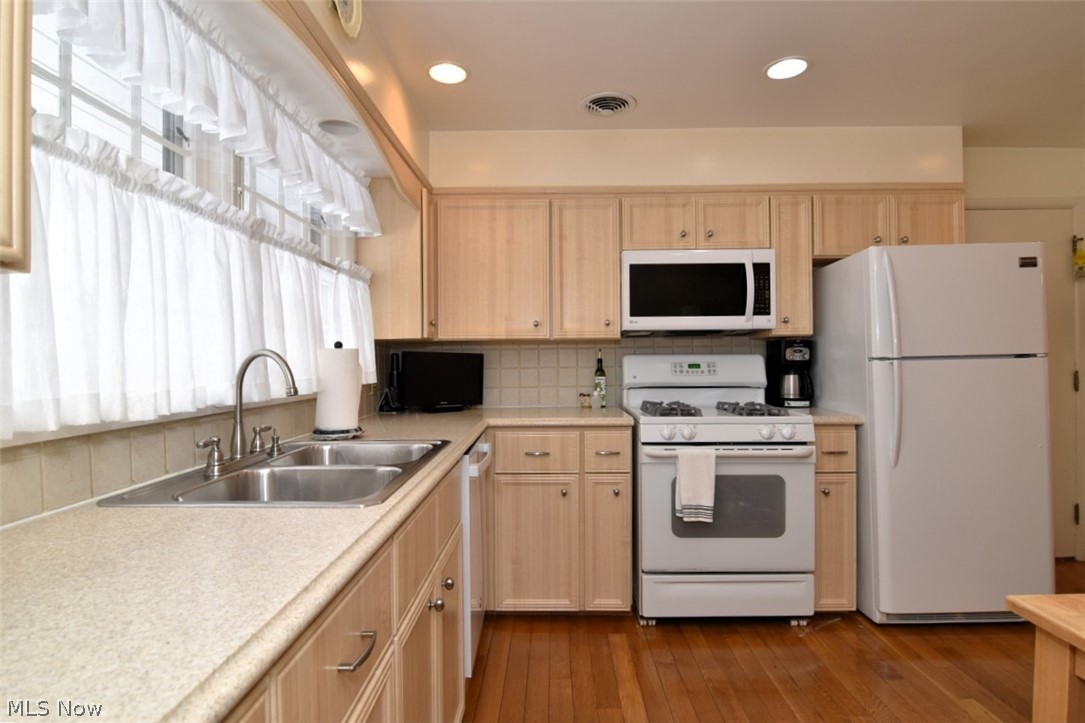 15991 Henley Road Cleveland, OH 44112 - Photo 17 of 36 Kitchen featuring light wood finish cabinetry, white appliances, light countertops, dark wood finished floors, and recessed lighting