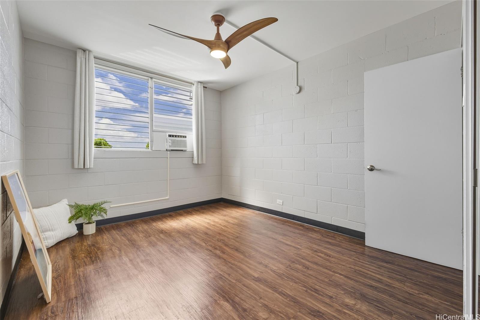 98-135 Lipoa Place, Unit 208 Aiea, HI 96701 - Photo 13 of 22 a view of an empty room with wooden floor and a window