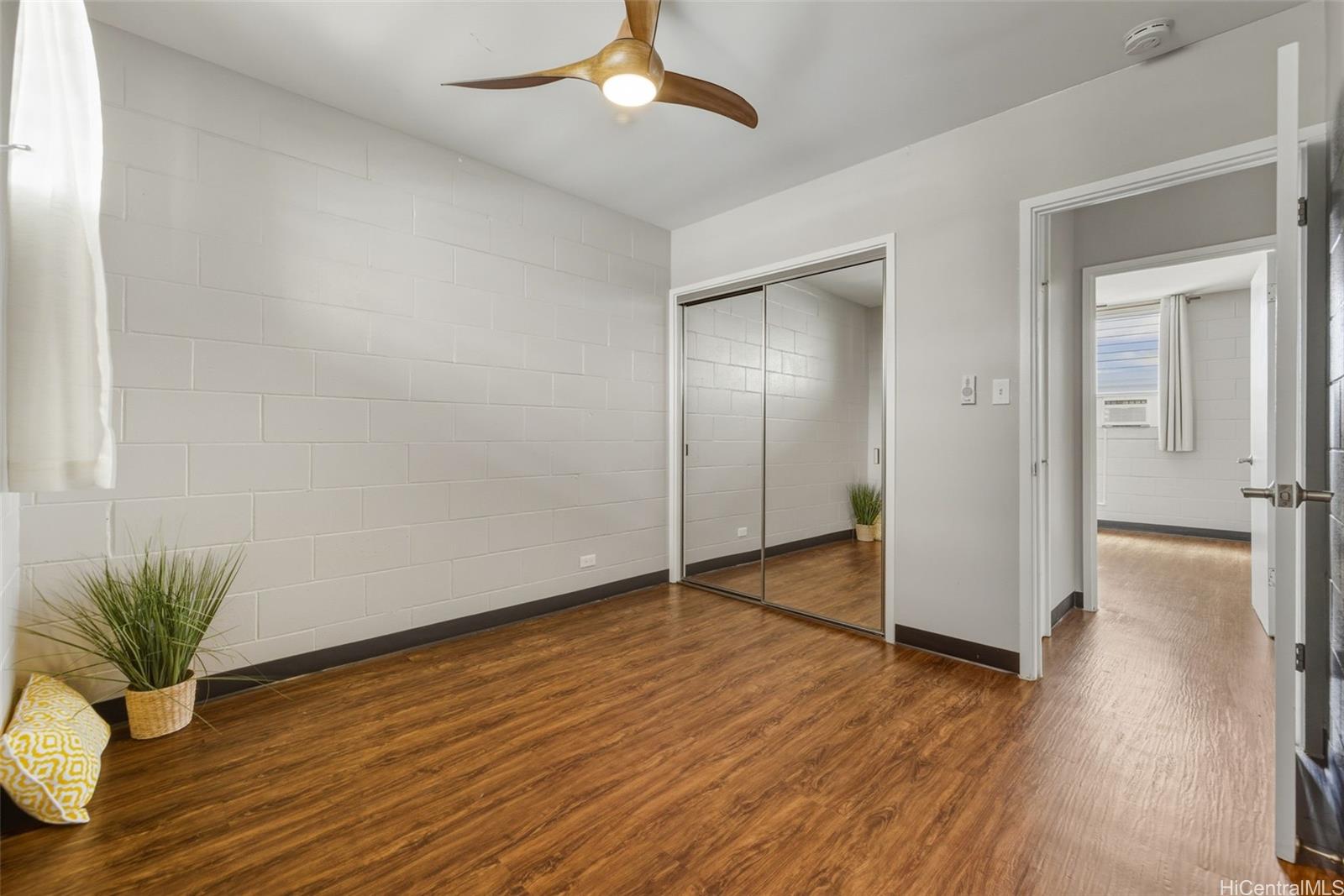 98-135 Lipoa Place, Unit 208 Aiea, HI 96701 - Photo 14 of 22 wooden floor in an empty room with a window