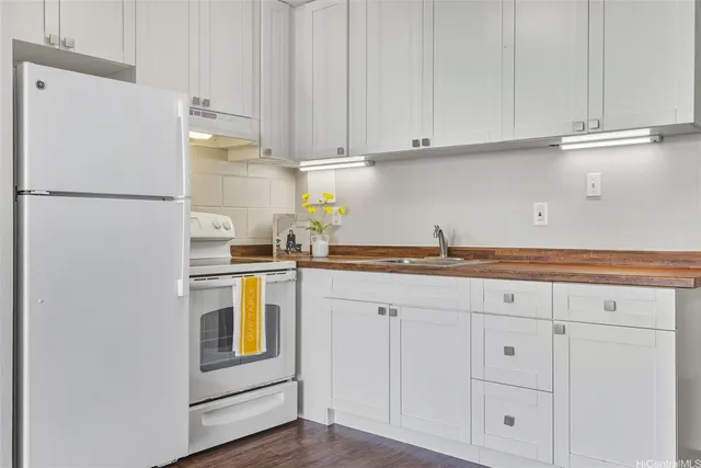 a kitchen with stainless steel appliances white cabinets and a refrigerator
