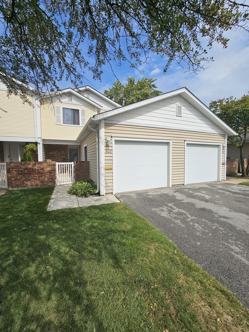 a view of a house with a yard and large tree