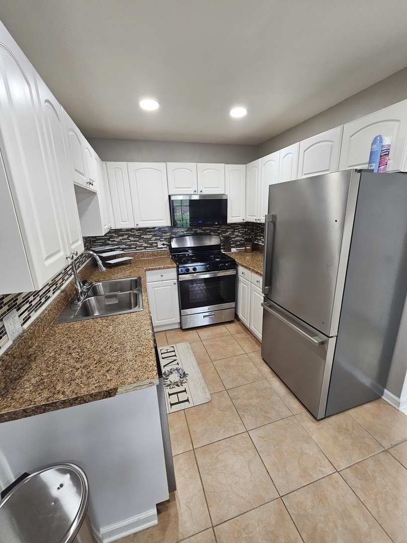 608 Bayview Point Schaumburg, IL 60194 - Photo 6 of 31 a kitchen with granite countertop a refrigerator and a sink