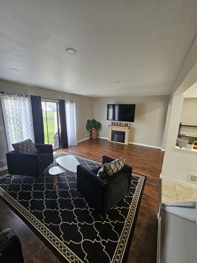 608 Bayview Point Schaumburg, IL 60194 - Photo 8 of 31 a living room with hard wood floors and a fireplace