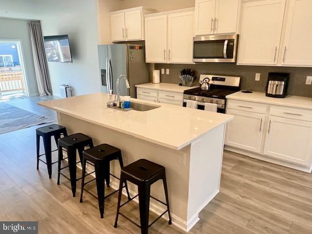 8804 Woodyard Station Road Clinton, MD 20735 - Photo 13 of 39 a kitchen with stainless steel appliances kitchen island a white table chairs and a refrigerator