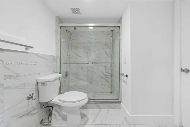 a bathroom with a toilet and a shower