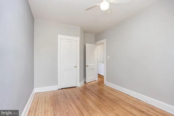 a view of a room with wooden floor and a ceiling fan