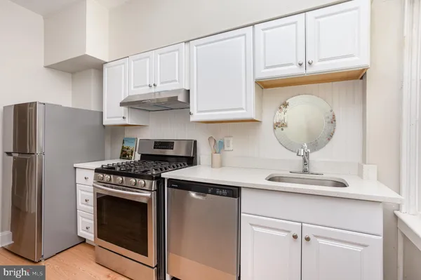 a kitchen with stainless steel appliances granite countertop a sink a stove and cabinets