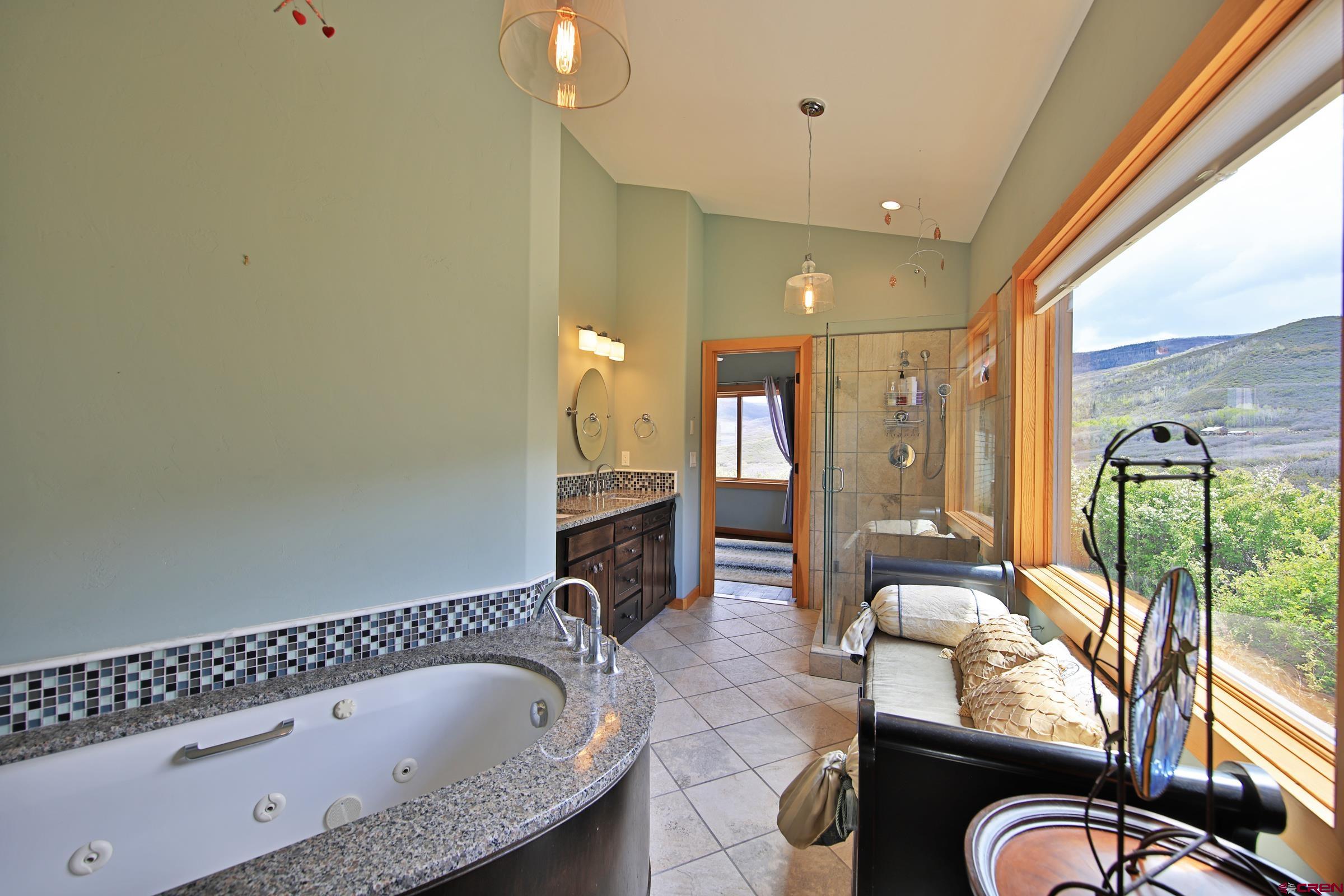 53315 Bull Basin Road Mesa, CO 81643 - Photo 11 of 44 a bathroom with a granite countertop sink mirror and bathtub