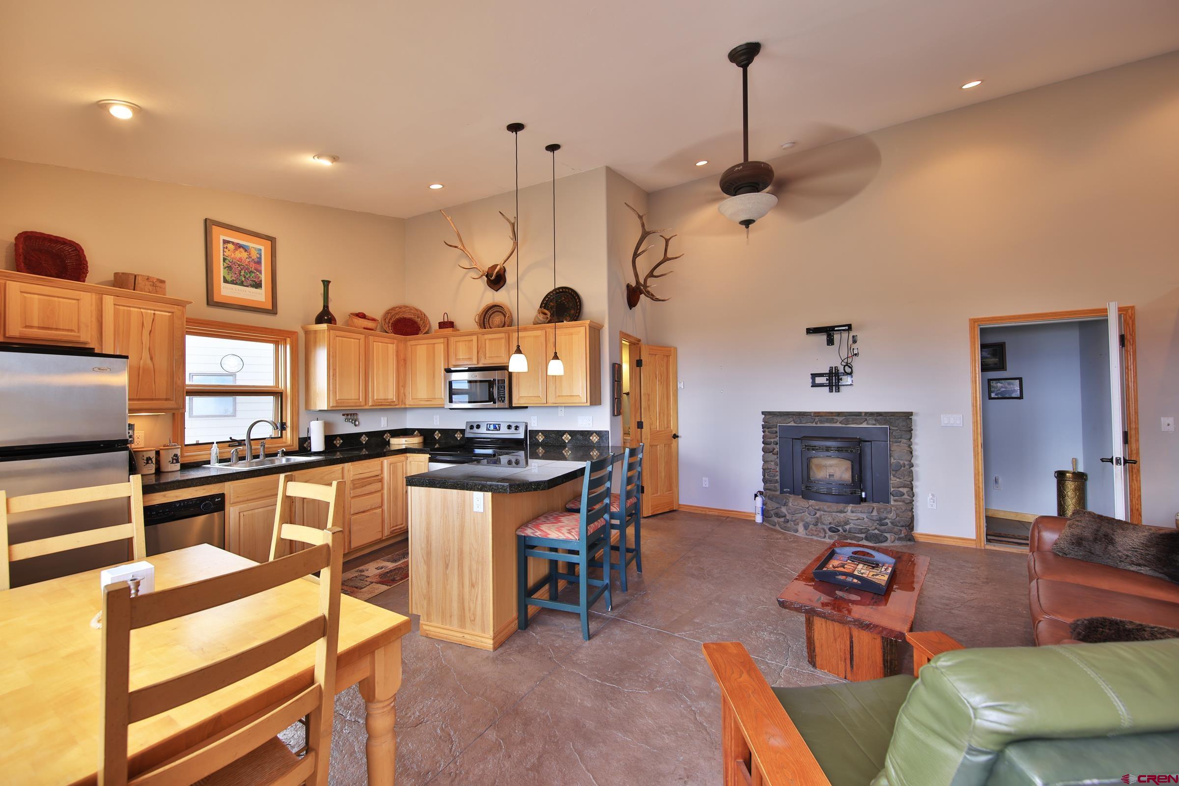 53315 Bull Basin Road Mesa, CO 81643 - Photo 22 of 44 a kitchen with stainless steel appliances granite countertop a stove and a fireplace
