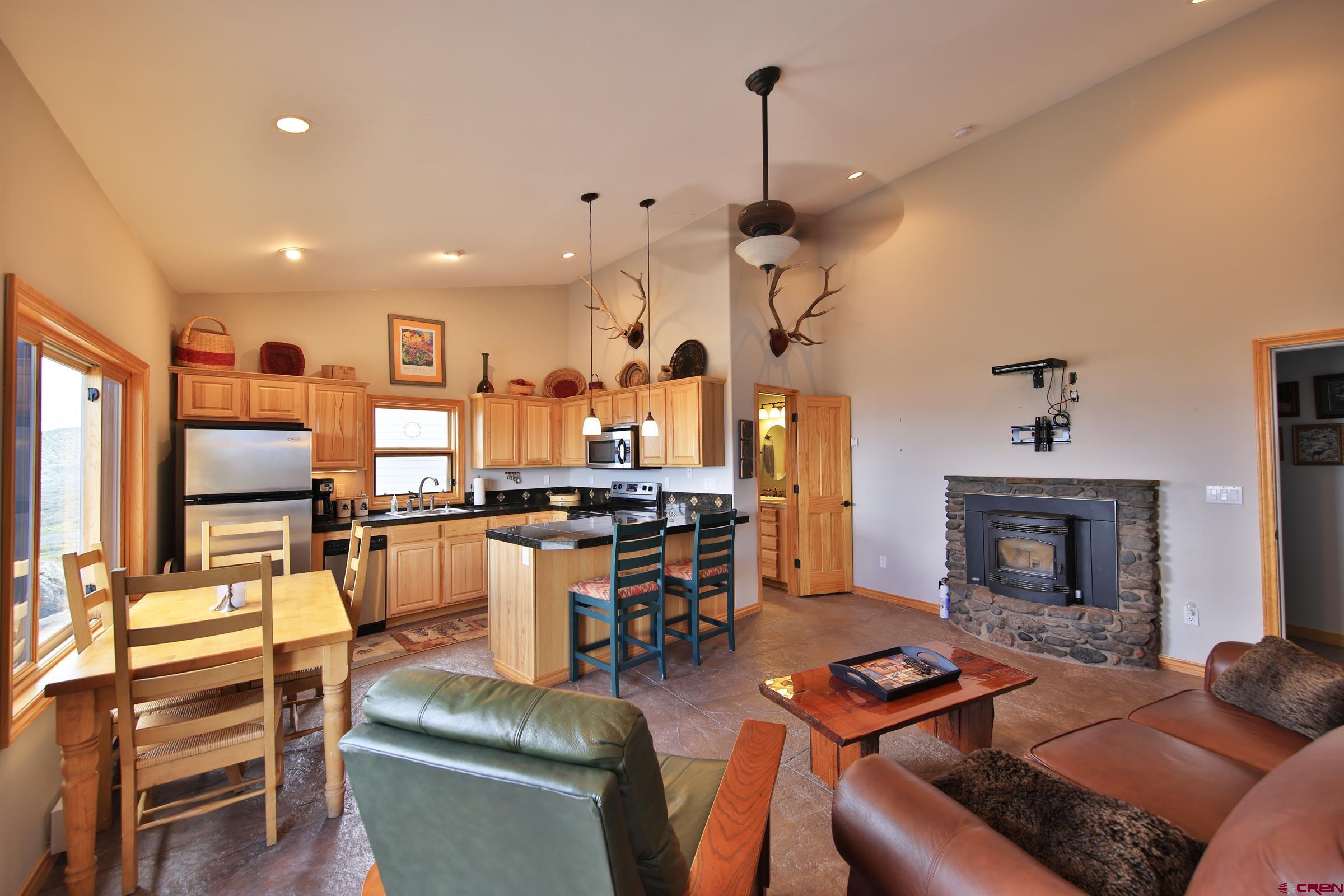 53315 Bull Basin Road Mesa, CO 81643 - Photo 24 of 44 a living room with furniture kitchen view and a fireplace