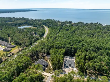 an aerial view of a house with a yard and lake view