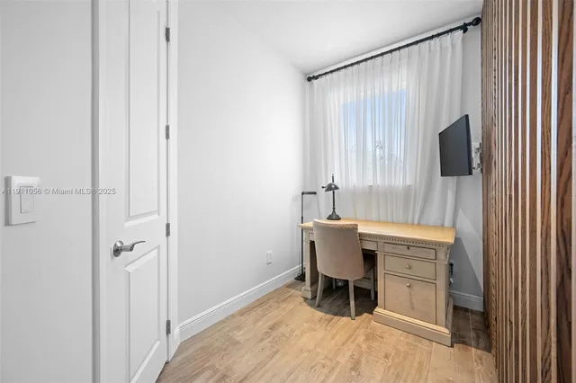 a view of a workspace with furniture and a window