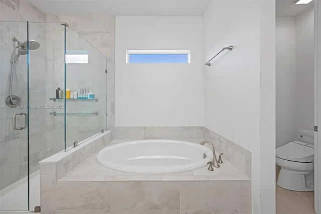 a white bath tub sitting next to a toilet
