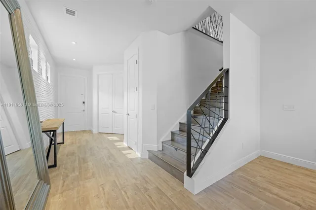 a view of a livingroom with wooden floor and stairs