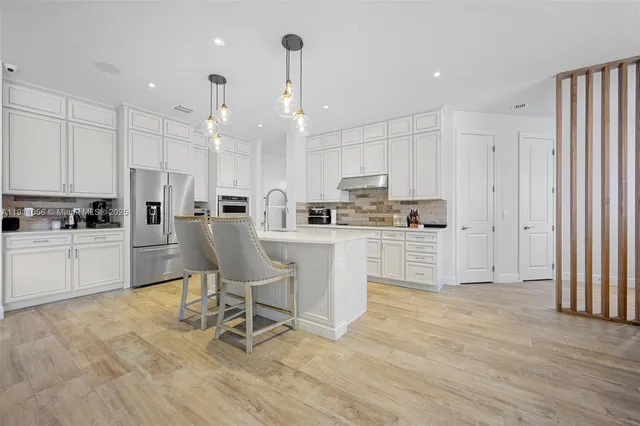 a kitchen with cabinets and chairs