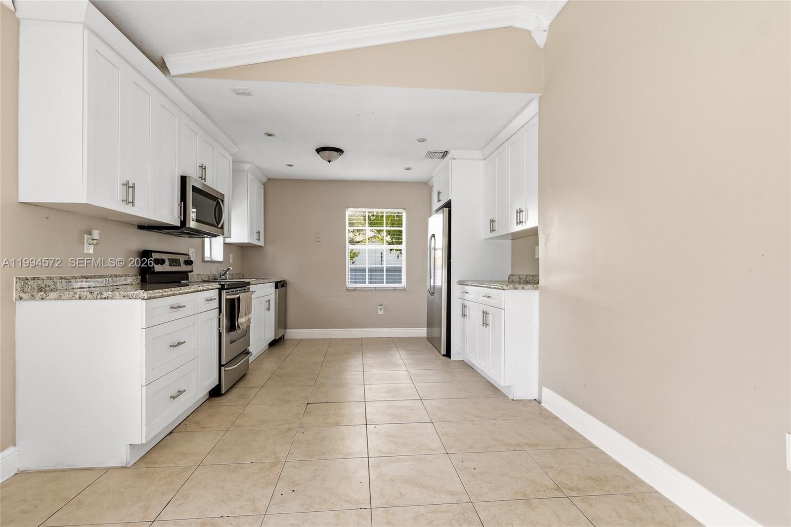 5730 Northwest 199th Street Hialeah, FL 33015 - Photo 11 of 33 a kitchen with cabinets and window