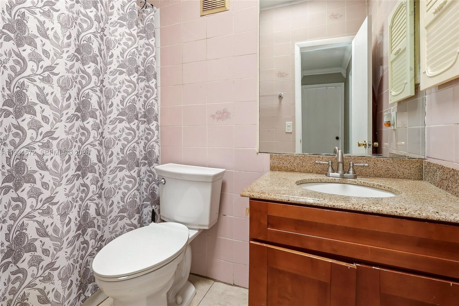 5730 Northwest 199th Street Hialeah, FL 33015 - Photo 26 of 33 a bathroom with a granite countertop toilet sink and mirror