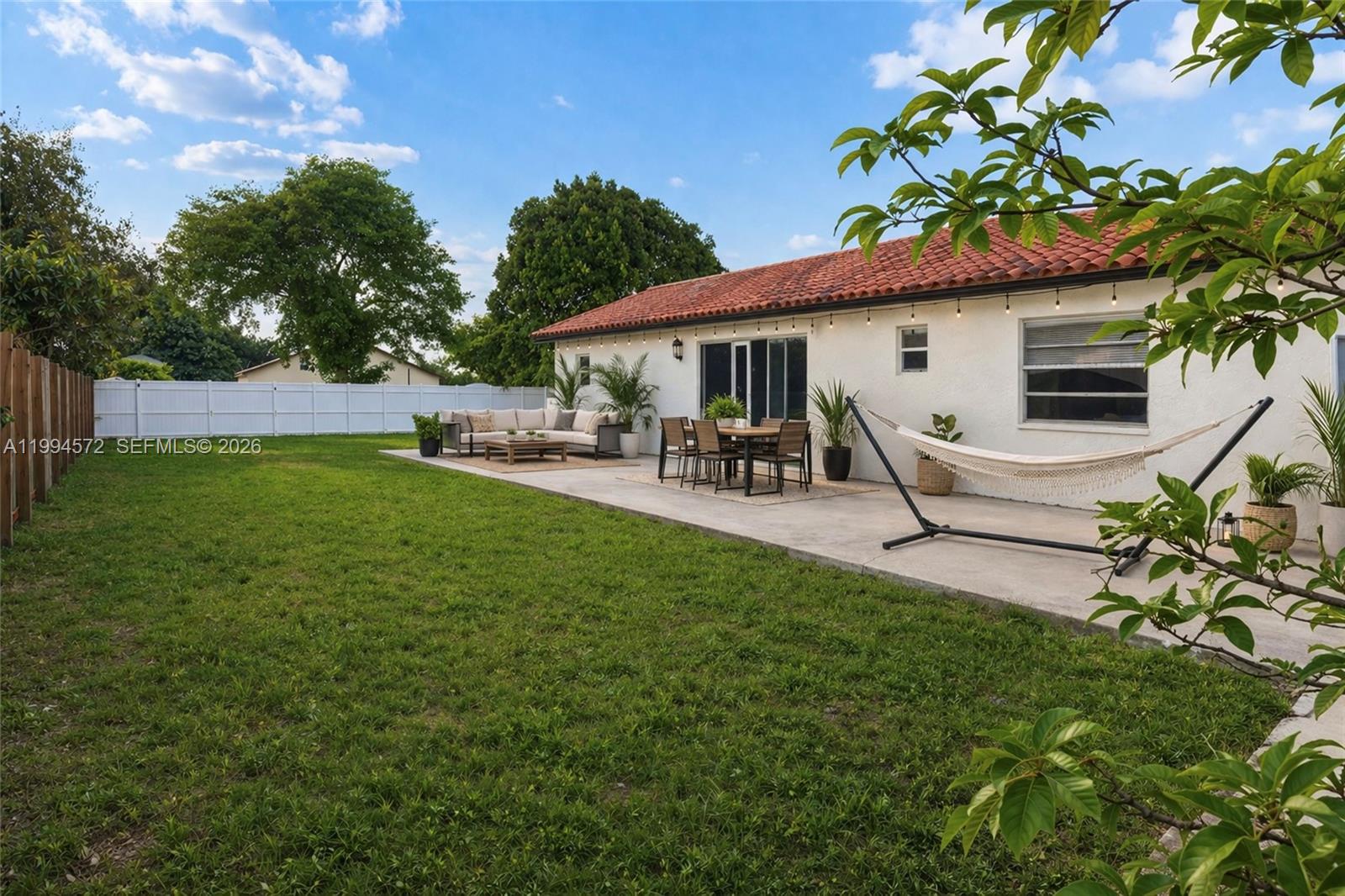 5730 Northwest 199th Street Hialeah, FL 33015 - Photo 32 of 33 a backyard of a house with table and chairs