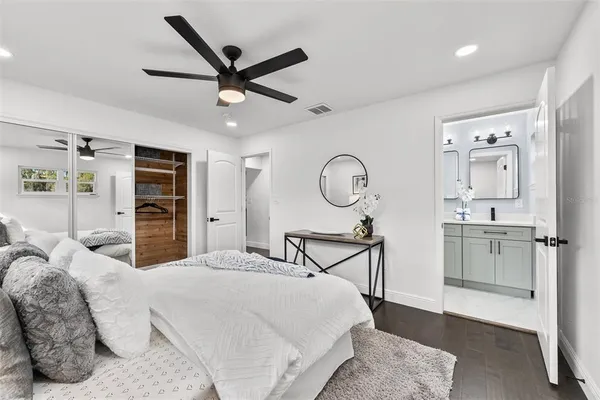 a bedroom with a bed a ceiling fan and a rug