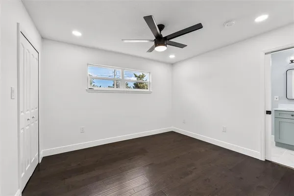 a view of a big room with wooden floor closet and windows