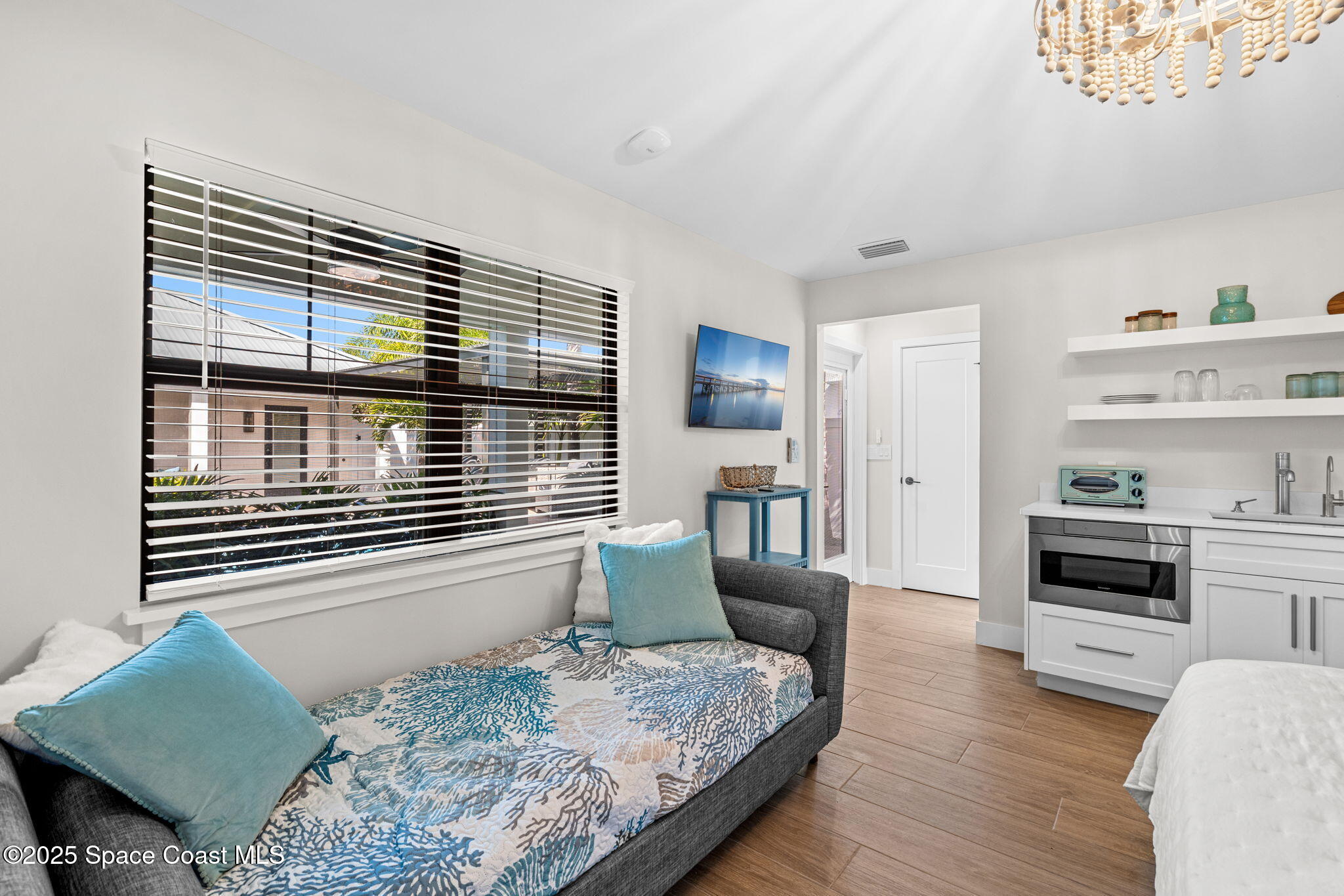 2021 South Orlando Avenue Cocoa Beach, FL 32931 - Photo 24 of 42 a bedroom with a bed and dresser with wooden floor