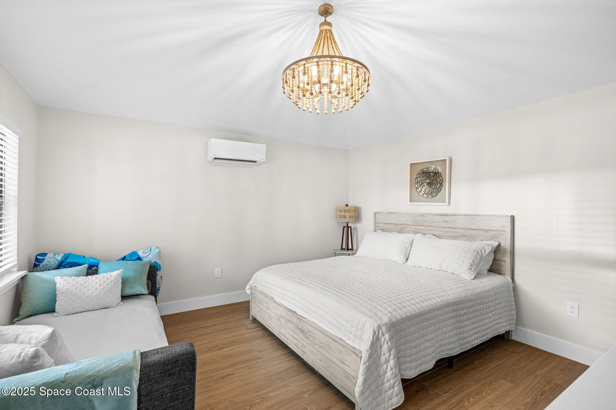 2021 South Orlando Avenue Cocoa Beach, FL 32931 - Photo 29 of 42 a bedroom with a bed and a chandelier