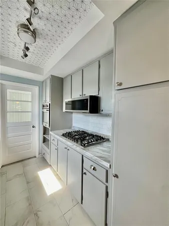 a large kitchen with stainless steel appliances granite countertop a stove a sink dishwasher and a refrigerator