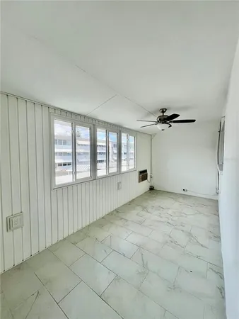 a view of a livingroom with a ceiling fan and window