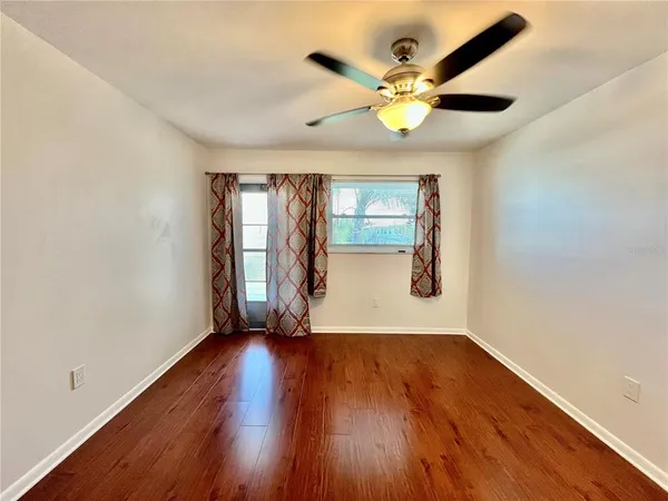 a view of an empty room with wooden floor