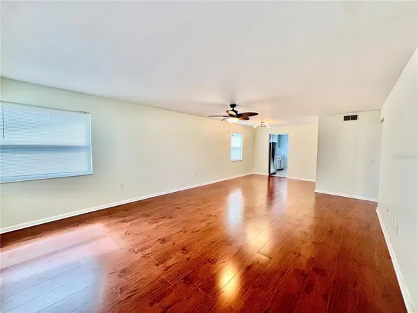 a view of empty room with wooden floor