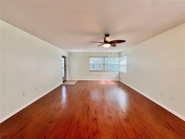 a view of empty room with wooden floor
