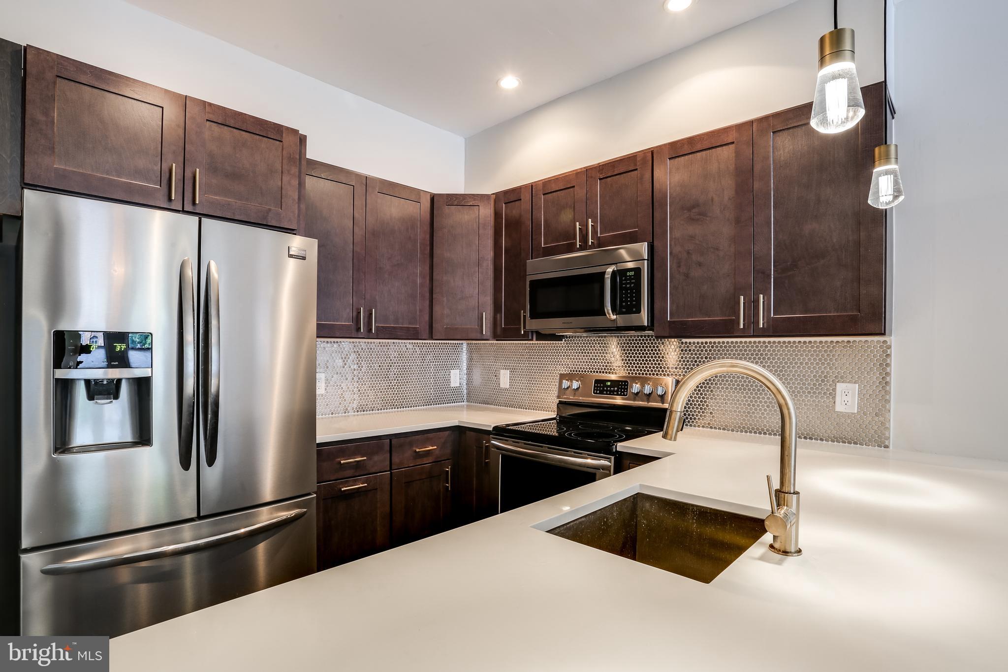 2007 Clipper Park Road, Unit 124 Baltimore, MD 21211 - Photo 16 of 35 a kitchen with granite countertop a refrigerator and a sink