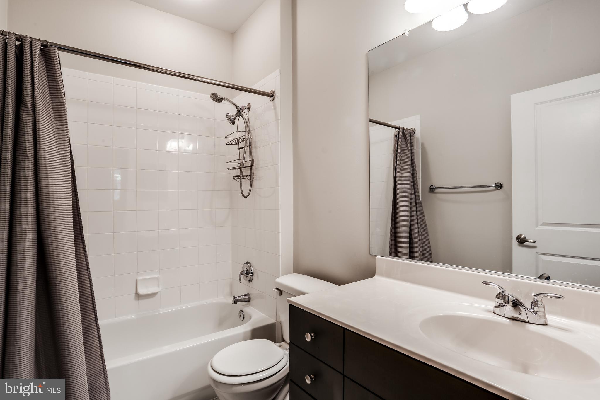 2007 Clipper Park Road, Unit 124 Baltimore, MD 21211 - Photo 17 of 35 a bathroom with a sink a toilet a bathtub a mirror and shower