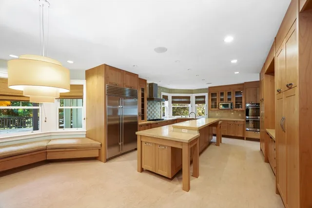a large kitchen with kitchen island a stove a sink dishwasher and wooden cabinets with wooden floor