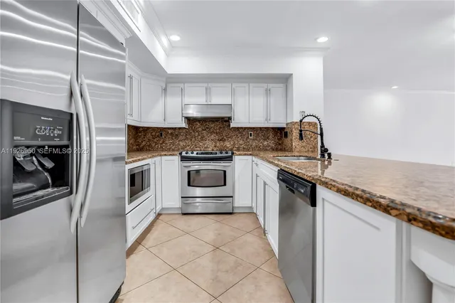 a kitchen with stainless steel appliances granite countertop a sink and cabinets