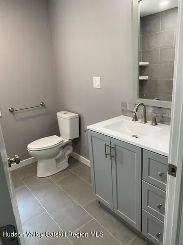 a bathroom with a sink toilet and a mirror