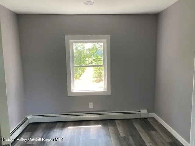 an empty room with wooden floor and window