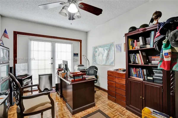 a view of a workspace with furniture and a book shelf
