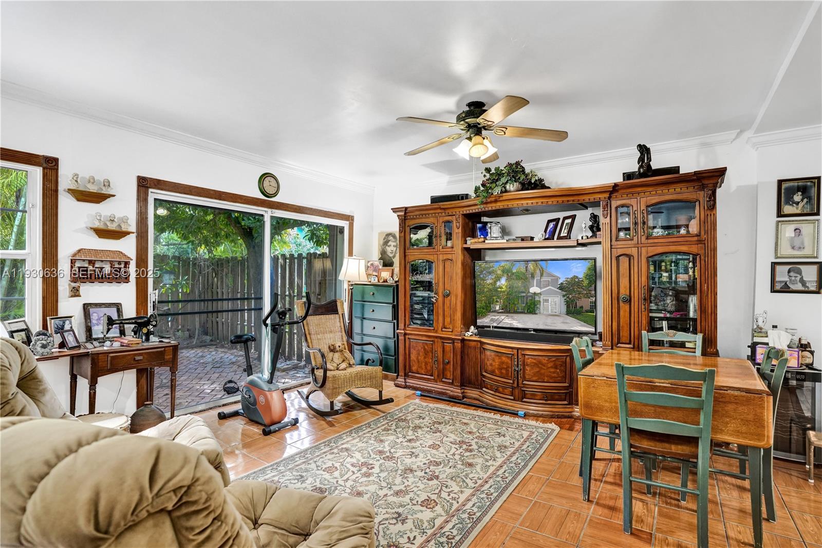 11728 Southwest 118th Terrace Miami, FL 33186 - Photo 6 of 31 a living room with furniture a flat screen tv and a floor to ceiling window