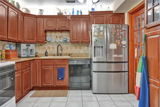 a kitchen with stainless steel appliances granite countertop a refrigerator and a sink