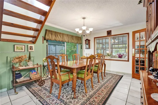 a dining room with furniture a rug a rug a rug and a chandelier