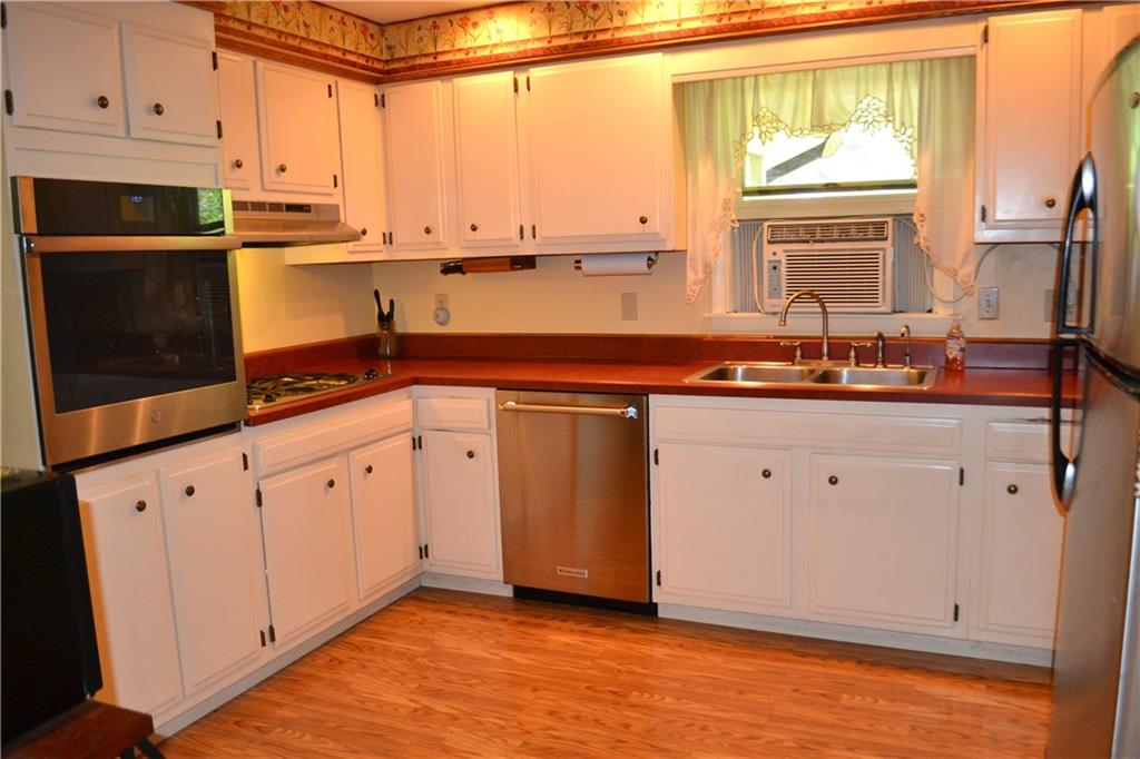 101 Locust Street Rural Valley, PA 16249 - Photo 5 of 16 a kitchen with stainless steel appliances granite countertop a sink a stove and white cabinets