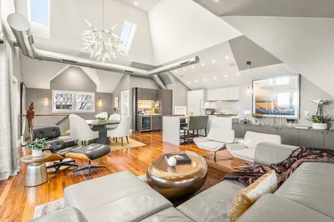 a living room with furniture kitchen view and a large window
