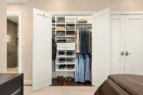 a view of walk in closet with clothes and shoes