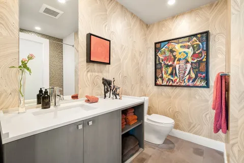 a bathroom with a sink a toilet and a large mirror
