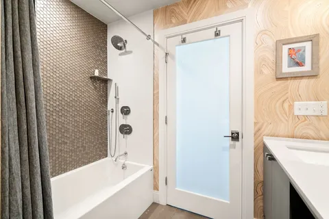 a bathroom with a tub a sink and a shower